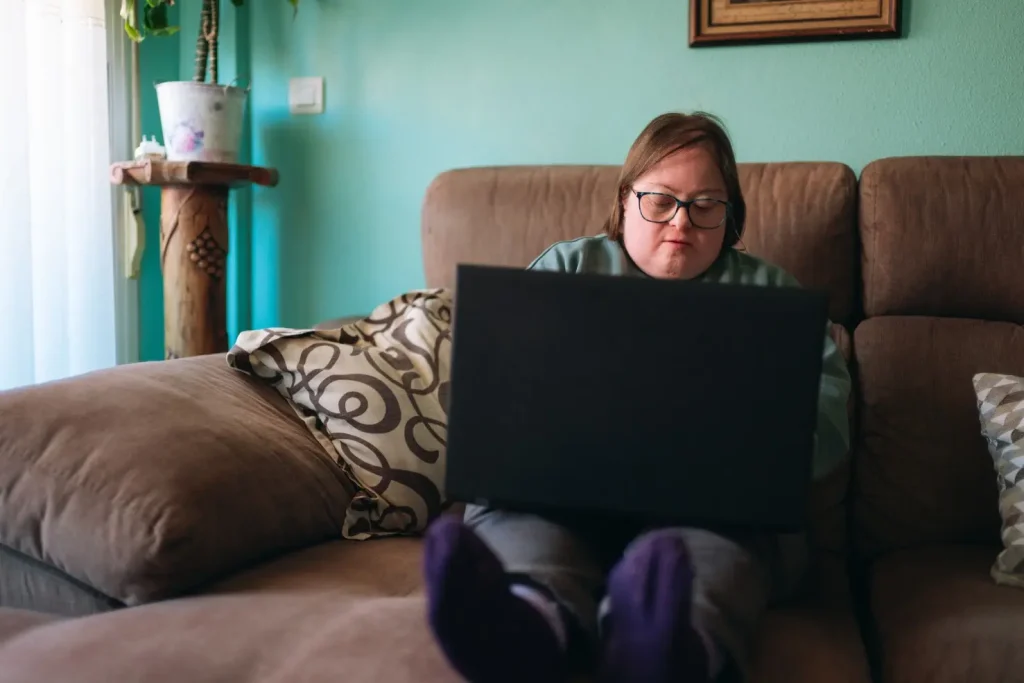 Disabled woman using laptop to contact Quality Assist Care