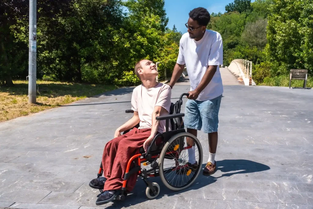 Disabled man in wheelchair smiling at support worker